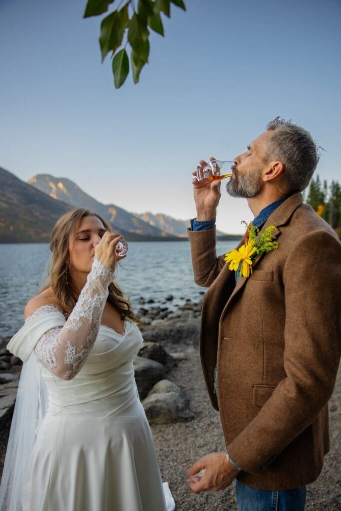 Bride and groom share their favorite whiskey on the shore
