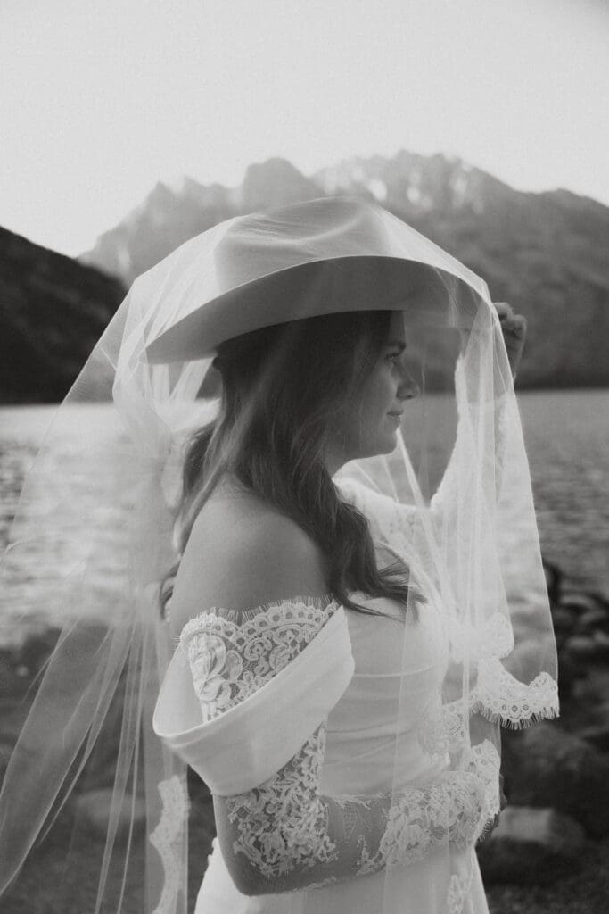 Bride poses with husband's cowboy hat