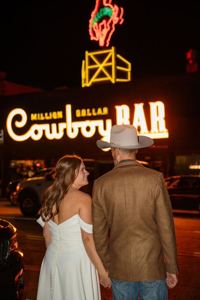 Bride and Groom walk towards Million Dollar Cowboy Bar