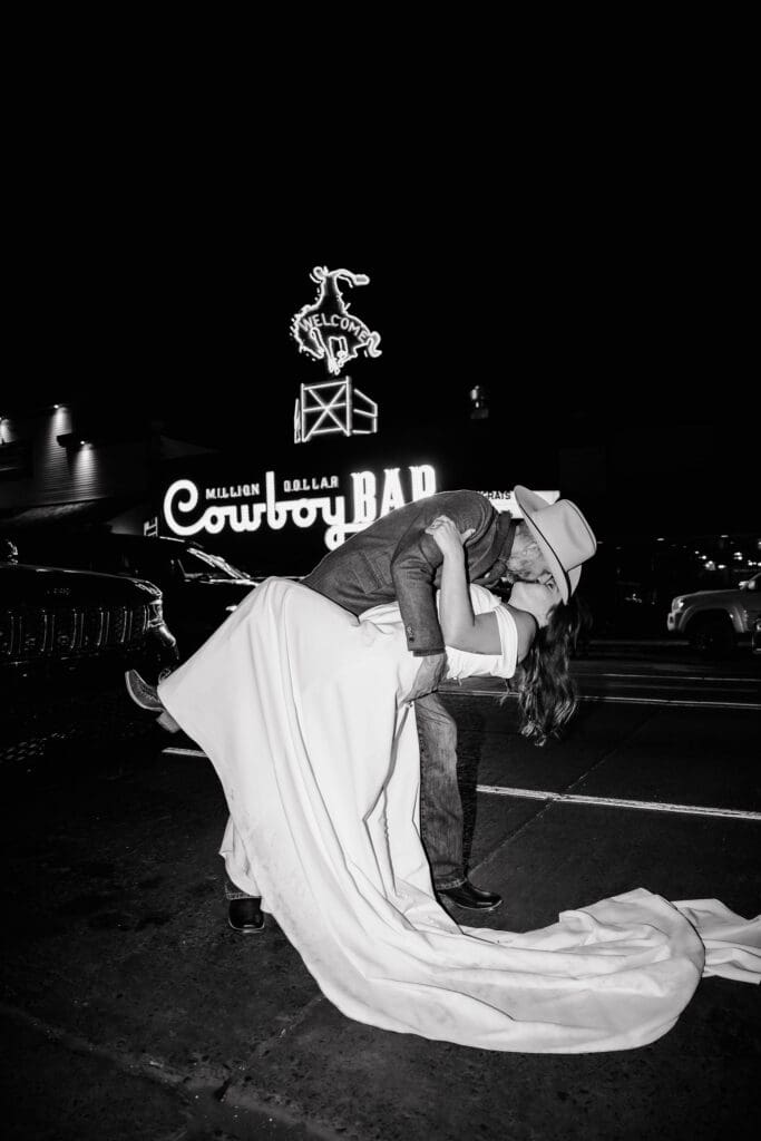 Bride and Groom share a dip kiss in front of Cowboy Bar in Jackson Hole, Wyoming