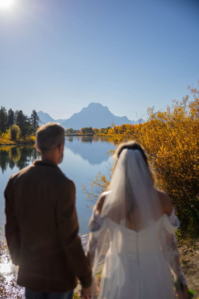 Couple admire Mount Moran that reflects in the water
