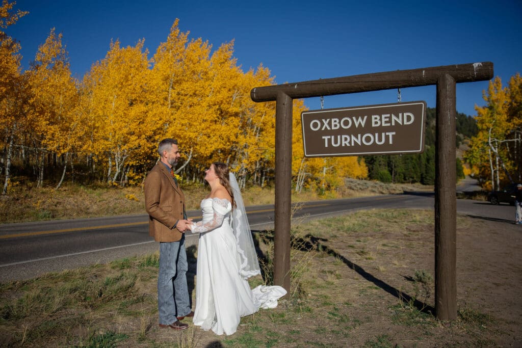 Couple poses in front of Oxbow Bend Turnout sign
