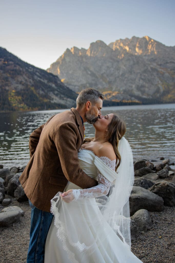 Couple share a kiss in front of the Grand Tetons