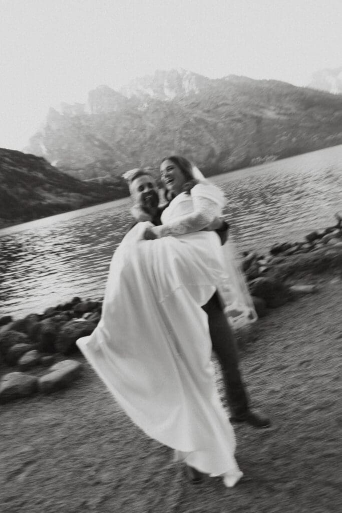 Groom lifts bride up for a photo