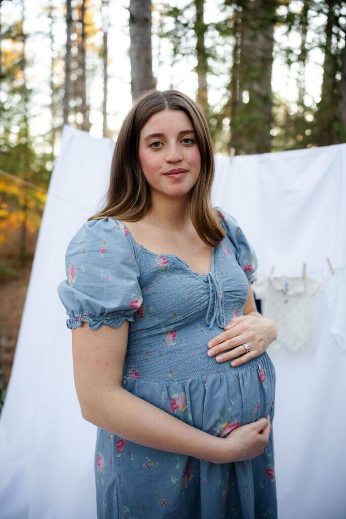 Maternity mother smiles for photo in Itasca forest