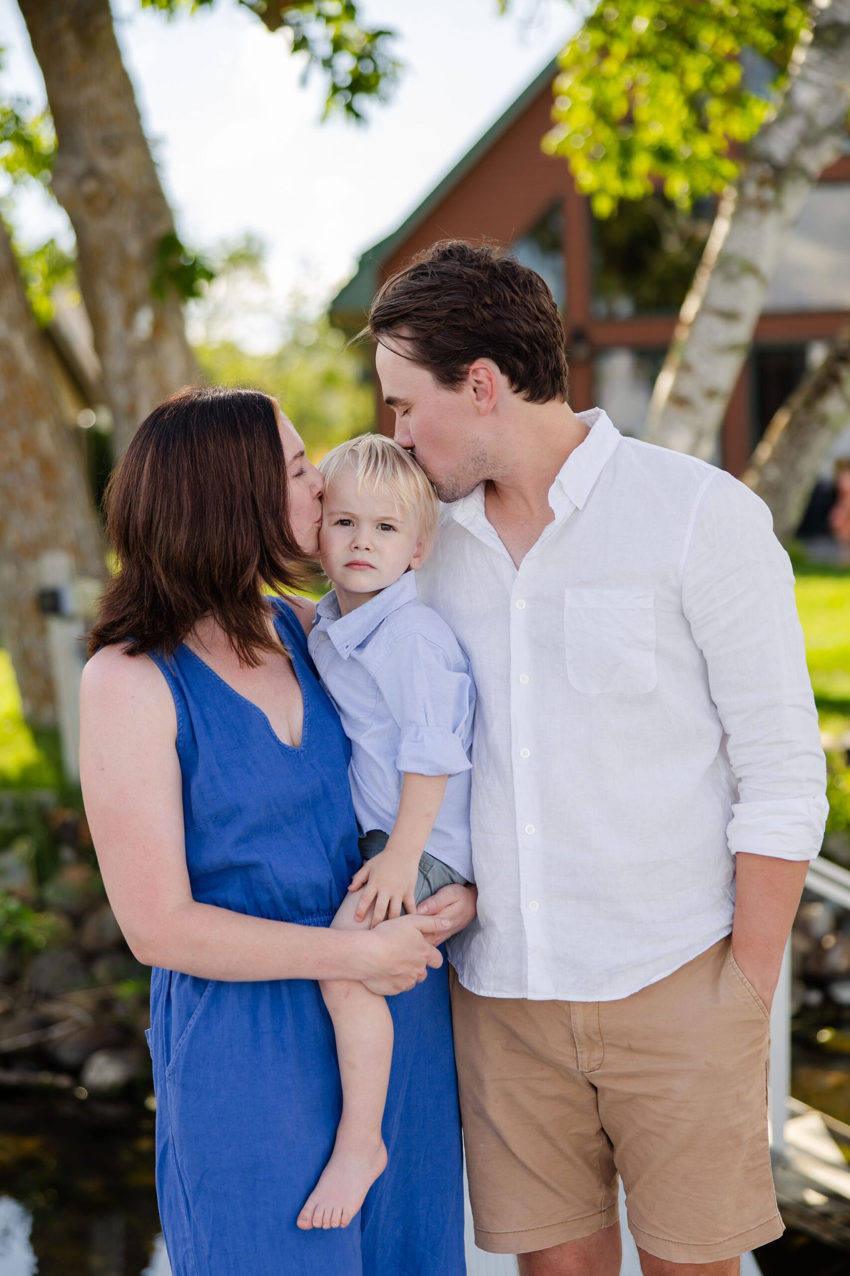 mom and dad kiss baby