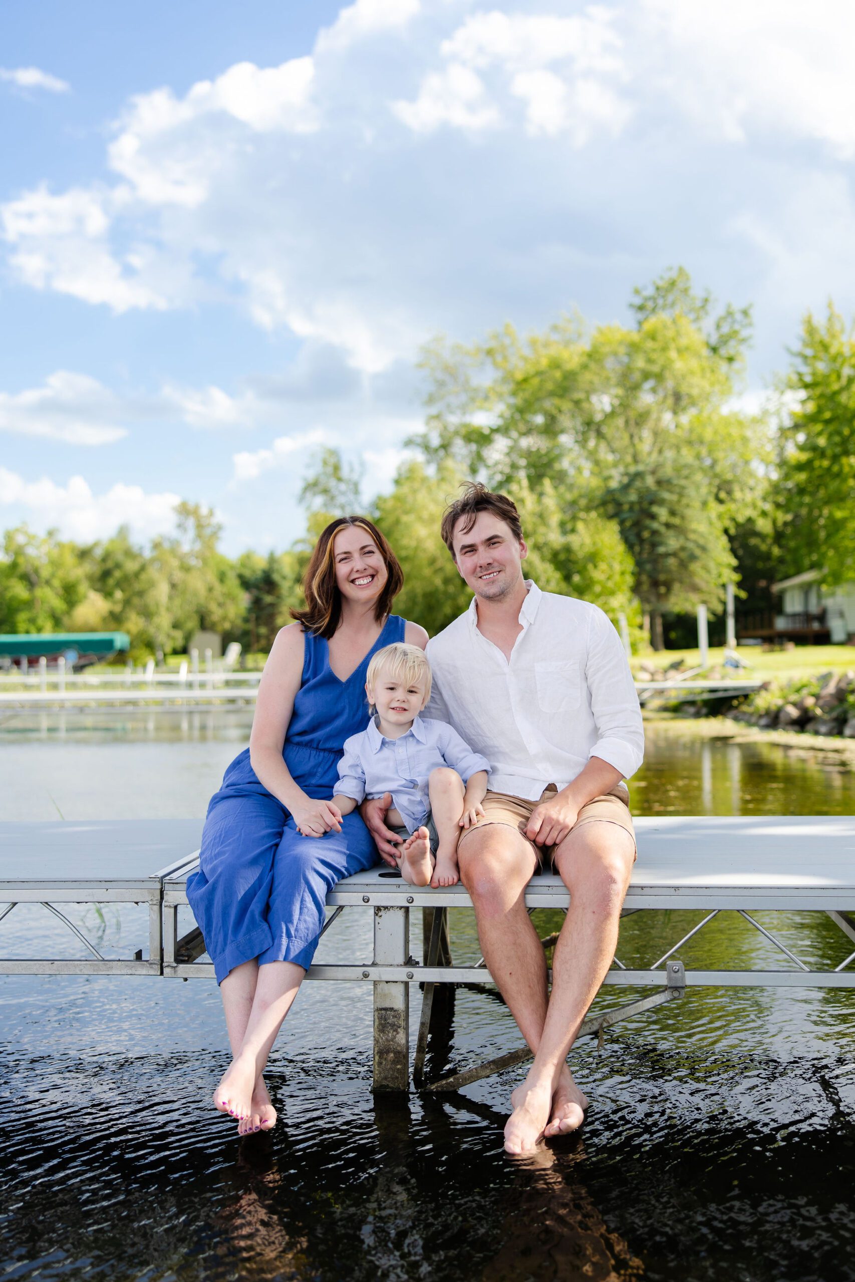 Family sits on the dock for photos 