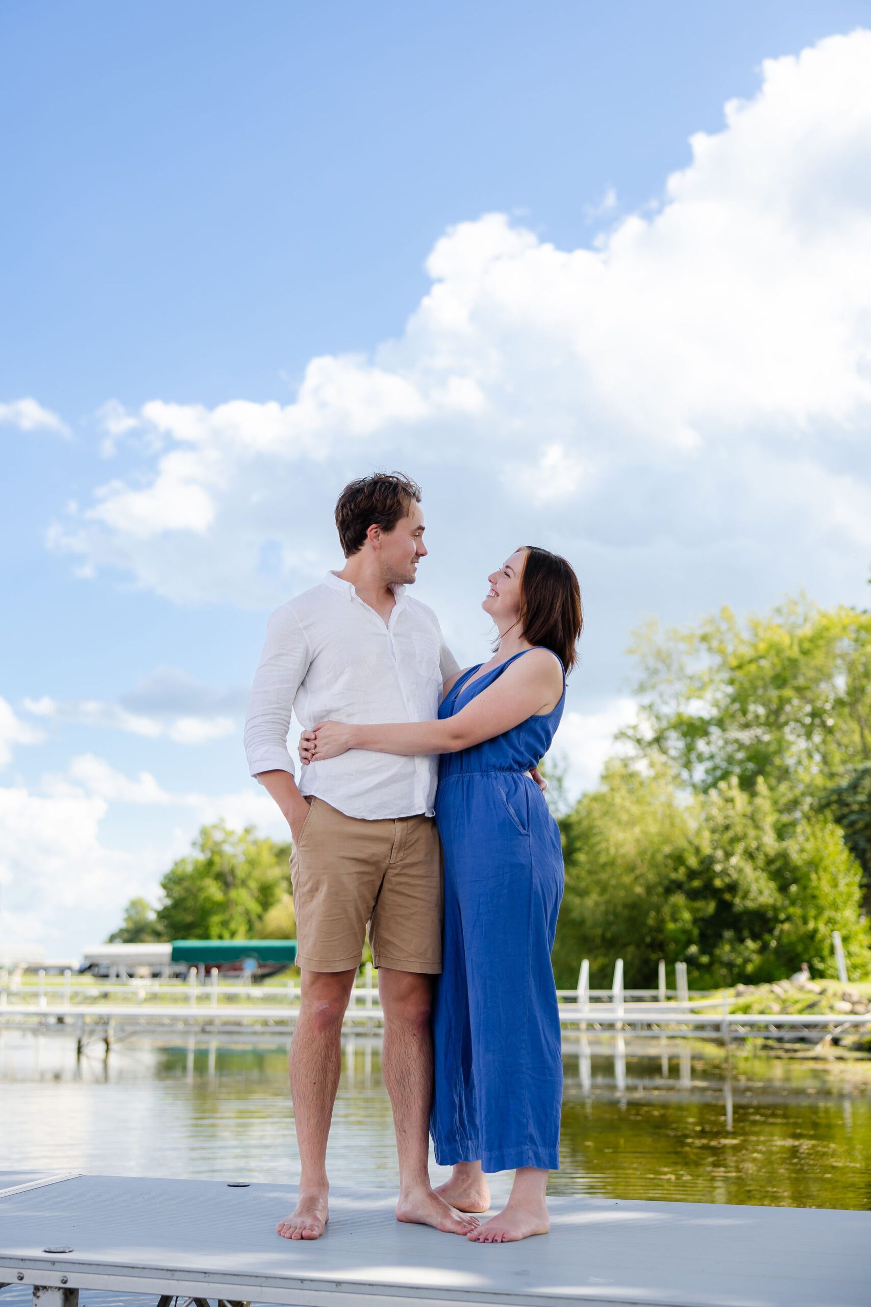 Mom and dad hug under blue skies