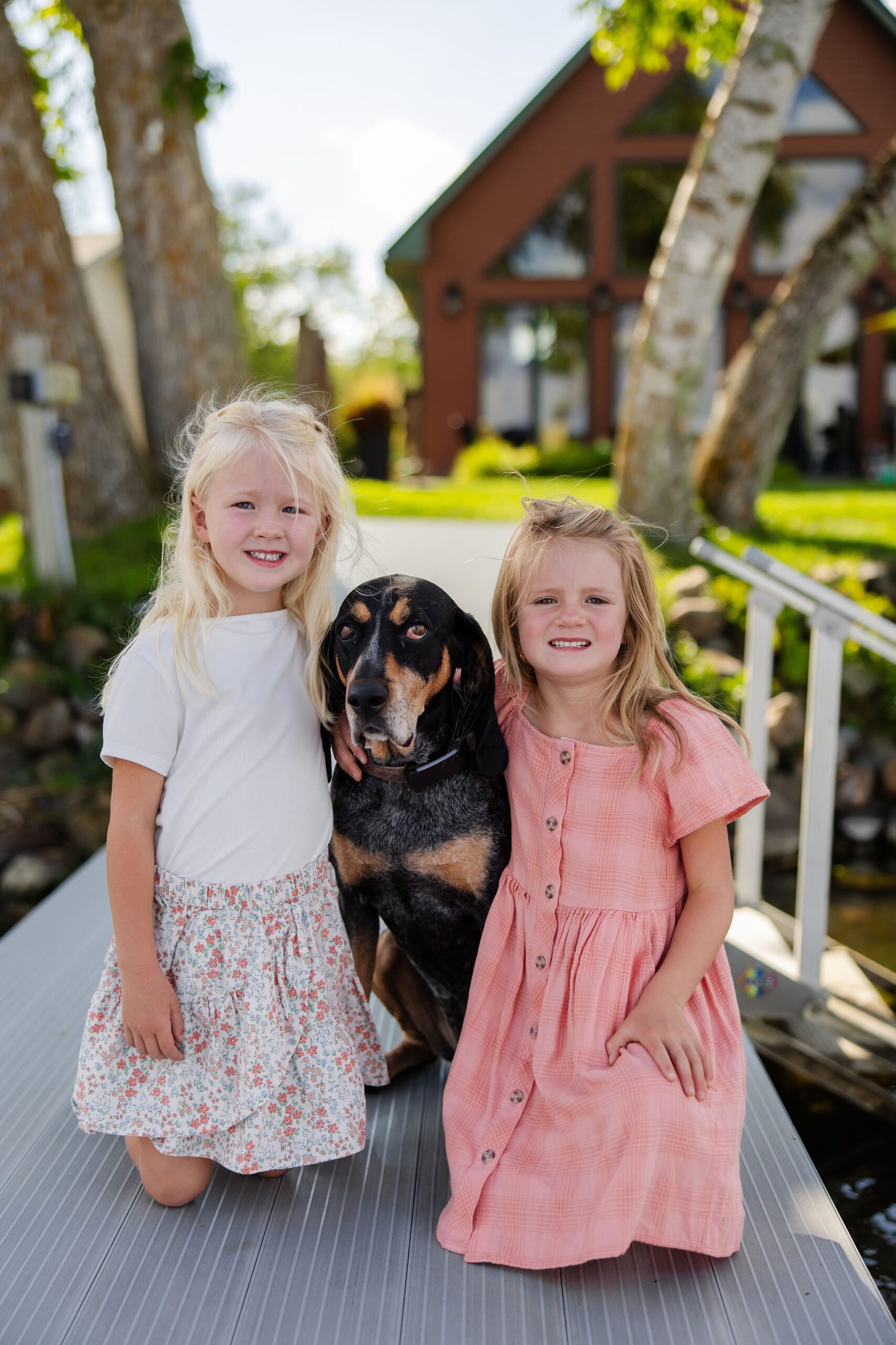 sisters hug their dog