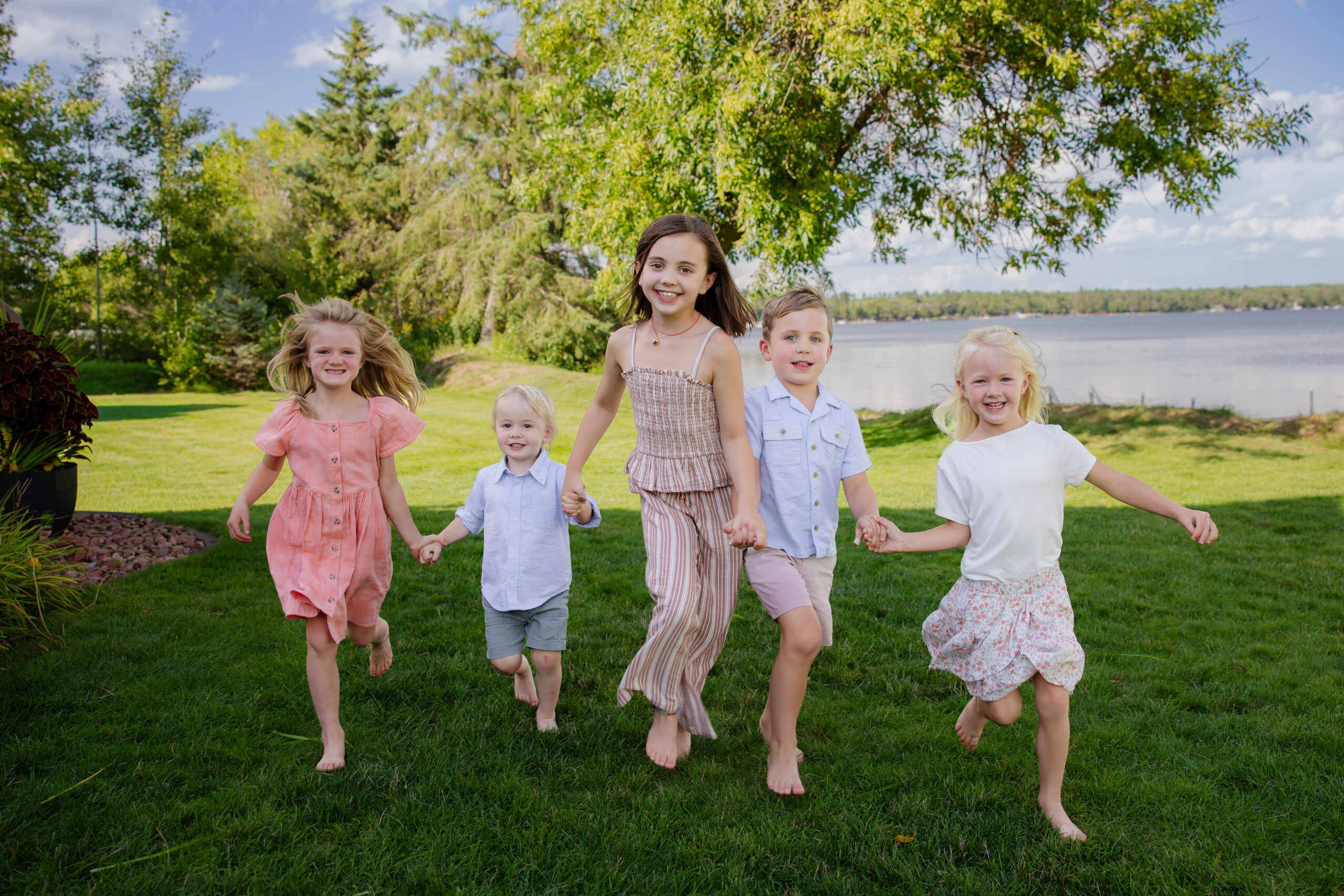 Grandkids run across front lawn at the cabin