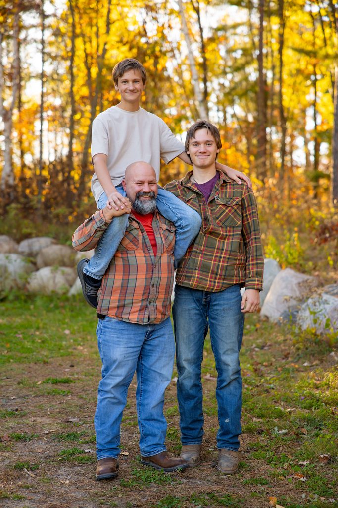 dad holds son on shoulders