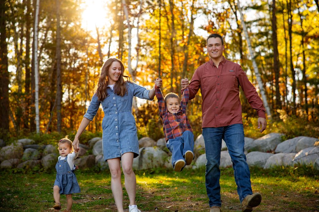 Father swings son for fall family photos