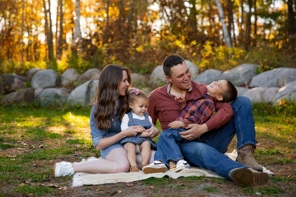 Family laughs while cuddled together for fall family photos