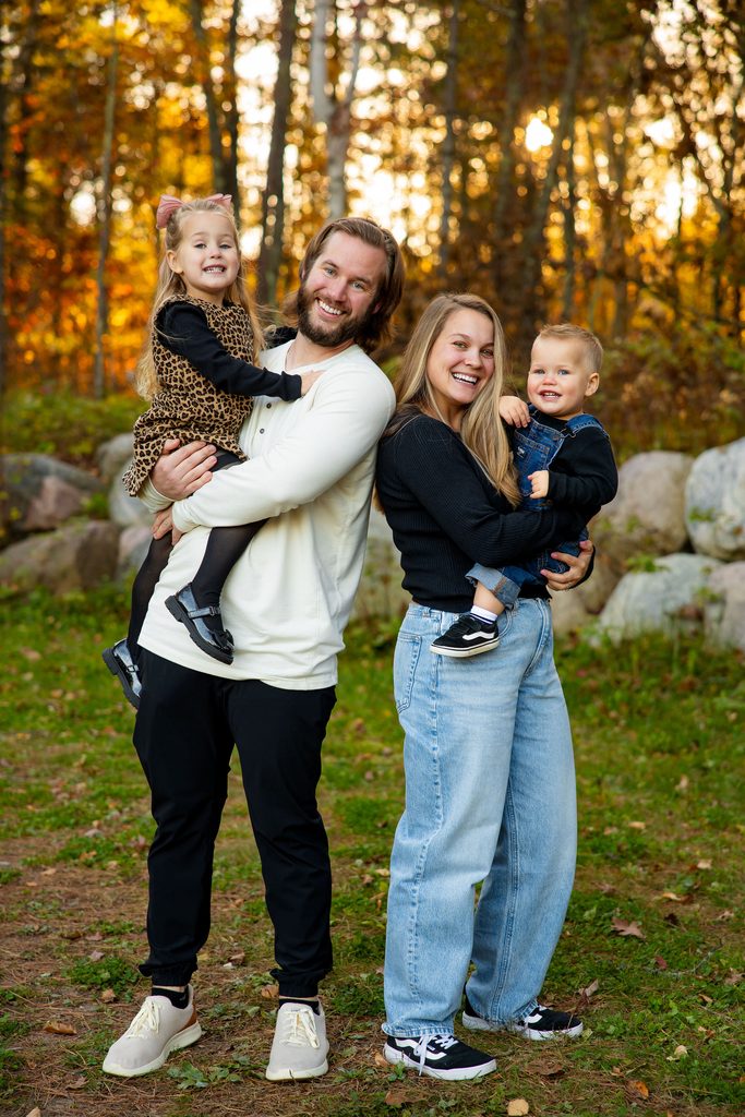 Family smiles for family photos in fall forest