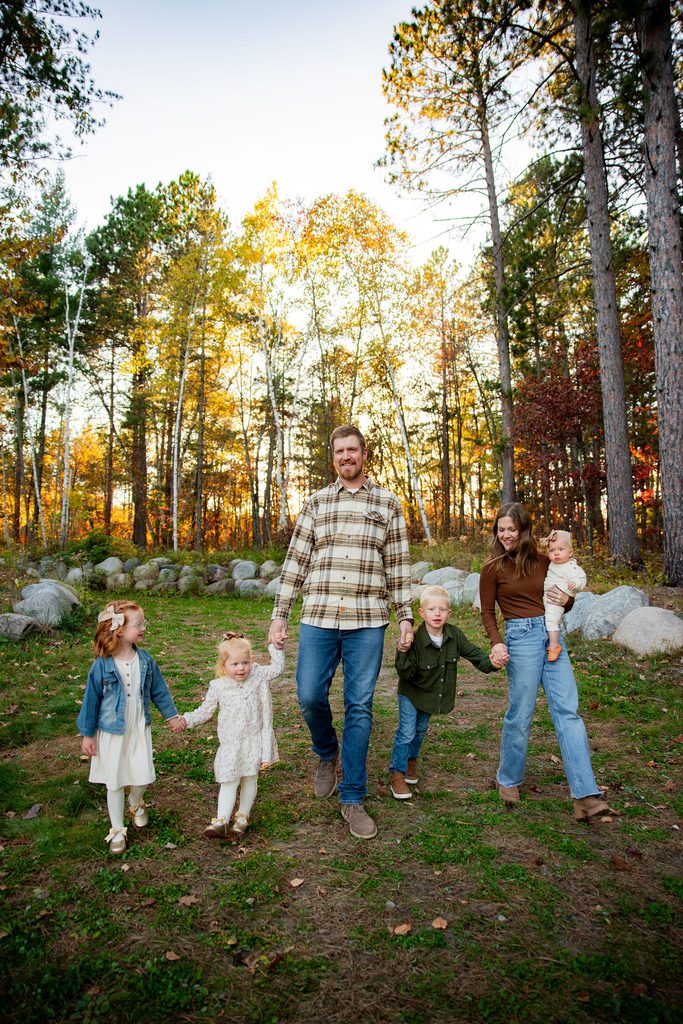 Family walks through fall color forest