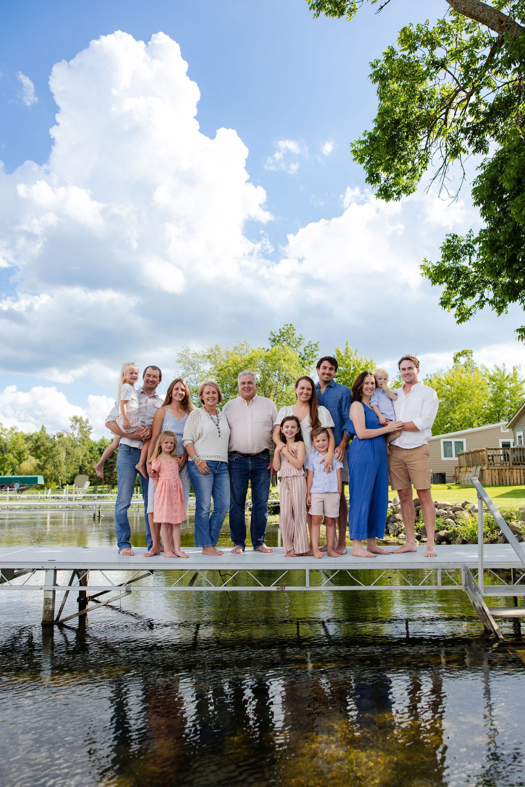 Extended family stands on dock for lakeside photos